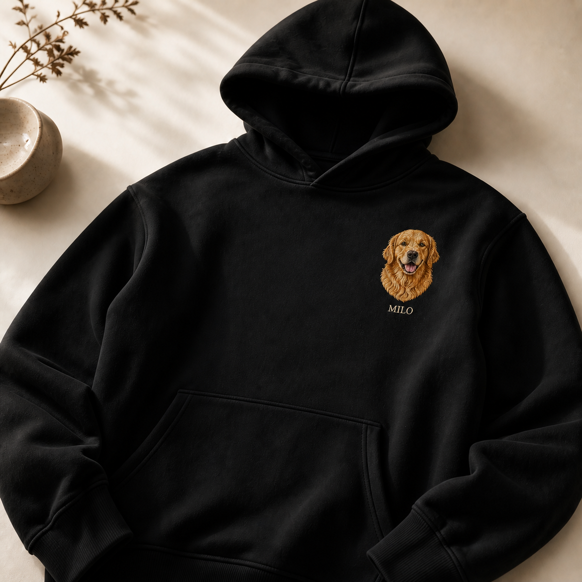 Schwarzer personalisierter PAWTRAIT Hoodie mit kleinem gesticktem Hundeporträt und Name auf der linken Brust